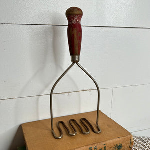 ANTIQUE MASHER WITH RED HANDLE