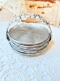 VINTAGE SET OF ALUMINUM DETAILED COASTERS AND HOLDER